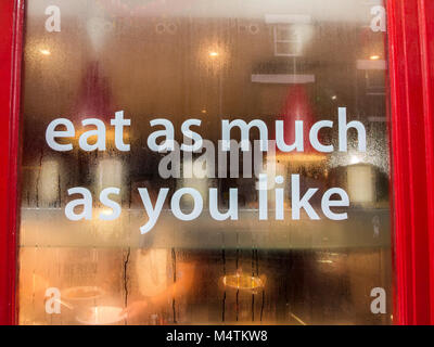 A sign in a restaurant window offering 'eat as much as you like' Stock Photo