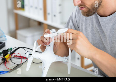 Close-up Of Male Hands Fixing Propeller Of Drone With Screw Driver At Workshop Stock Photo