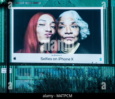 Old woman and teenage girl, pouting, entitled 'Selfies on iPhone X by Brianna Y'. Blowup media giant poster on the M4 motorway near London, UK. Stock Photo