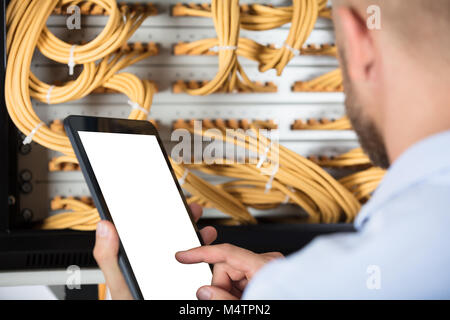 Male Technician Working On Server In The Data Center Using Cellphone Stock Photo