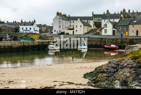 Small fishing boats in picturesque harbour at low tide, Portsoy, Aberdeenshire, Scotland, UK Stock Photo