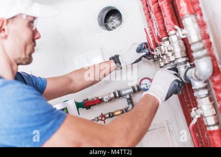 Professional Plumber Work. Caucasian Worker Checking on Water Valves. Stock Photo