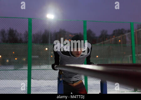 Image of sporty man pulling up on bar in evening at moon Stock Photo