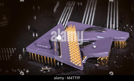 Broken computer processor on mainboard background. Fragments of  central processing unit. Electronics industry, hardware, ICT and cyber security idea. Stock Photo
