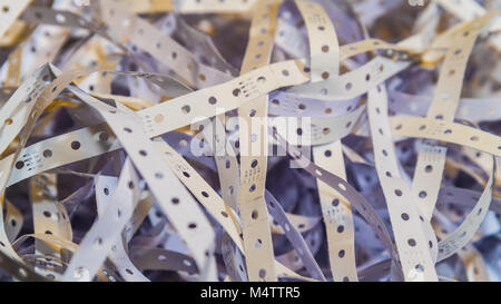 Close-up of tangle from perforated papery strips. Distinctive abstract texture from the edges of obsolete paper used in a computer printers. Stock Photo