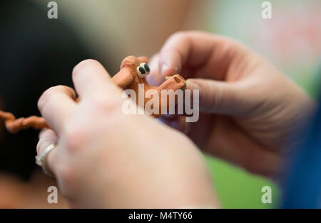 A child making a plasticine model using clay plasticine during a craft workshop. Stock Photo