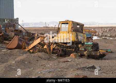 The old broken disassembled tractor thrown in the field Stock Photo