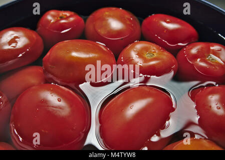 Roma tomatoes floating in the water. Stock Photo