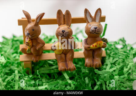 decoration rabbits sitting on a bench near a window Stock Photo