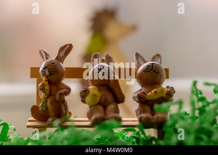 decoration rabbits sitting on a bench near a window Stock Photo