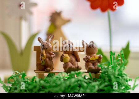 decoration rabbits sitting on a bench near a window Stock Photo