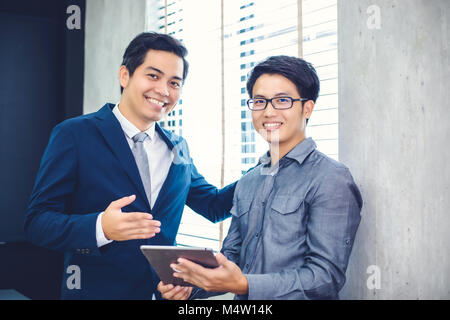 Asian businessmen and group using notebook for business partners discussing documents and ideas at meeting and business women smiling happy for workin Stock Photo