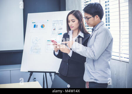 Asian businesswomen and group using notebook for business partners discussing documents and ideas at meeting and business women smiling happy for work Stock Photo