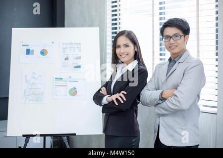 Asian businesswomen and group using notebook for business partners discussing documents and ideas at meeting and business women smiling happy for work Stock Photo