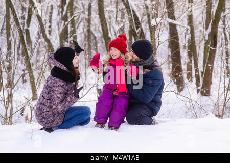 Happy young family in winter forest Stock Photo