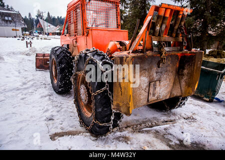 Logging machine giant wheels equipped with snow chains. Winter concept. Stock Photo
