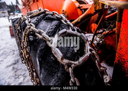 Logging machine giant wheels equipped with snow chains. Winter concept. Stock Photo
