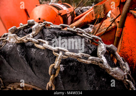 Logging machine giant wheels equipped with snow chains. Winter concept. Stock Photo