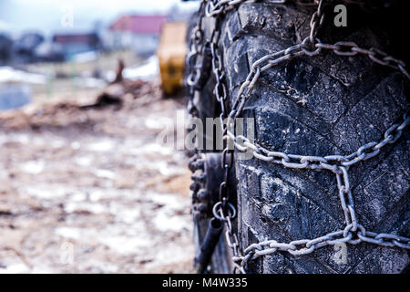 Logging machine giant wheels equipped with snow chains. Winter concept. Stock Photo