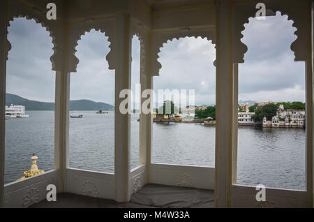 Lake Pichola and City Palace seen through 4-panel, scalloped Indian windows in Udaipur, India. Stock Photo