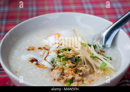 Rice porridge pork minced egg in bowl with tartan pattern background Stock Photo