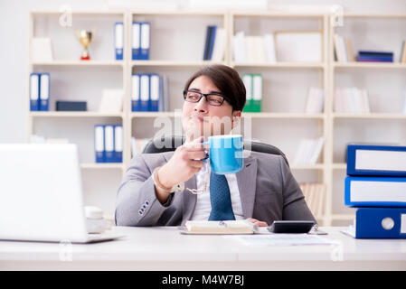 Businessman chained with handcuffs to his coffee Stock Photo