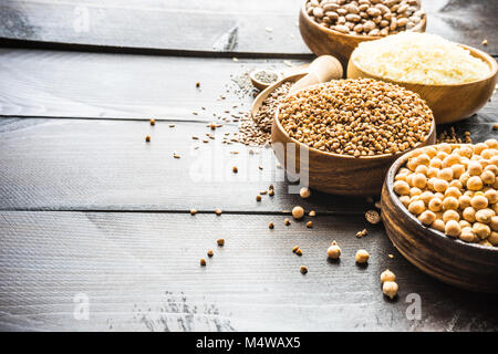 Organic superfood concept with raw chick peas, buckwheat, beans, rice, chia and flax seeds on wooden background Stock Photo