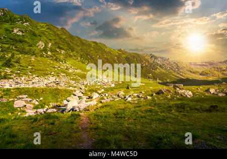 beautiful valley of Fagaras mountains. small brook flow among the rocks. grassy slopes with huge boulders Stock Photo