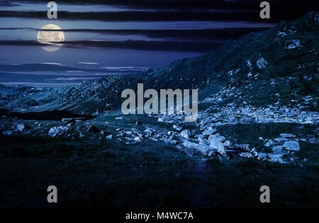 beautiful valley of Fagaras mountains. small brook flow among the rocks. grassy slopes with huge boulders Stock Photo