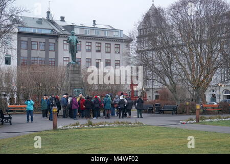 A walking tour of tourists by the statue of Jón Sigurðsson in Austurvöllur Park opposite the Parliament House in Reykjavik, Iceland Stock Photo
