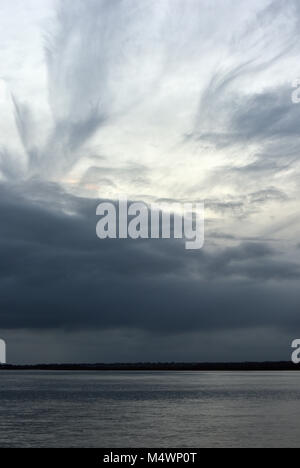 A stormy, atmospheric and interesting sky and cloudy structure over the salt marshes at Pennington near lymington in the new forest, Hampshire, uk. Stock Photo