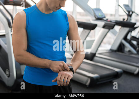 Mid section portrait of unrecognizable muscular man checking fitness tracker after working out in gym, copy space Stock Photo