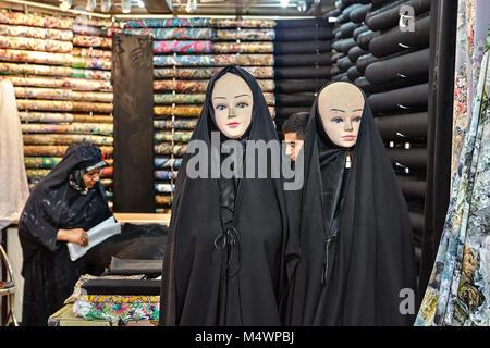 Tehran, Iran - April 29, 2017: Two mannequins dressed in black Islamic clothes, a religious veil of a chador, in the cloth department of the Tehran Gr Stock Photo