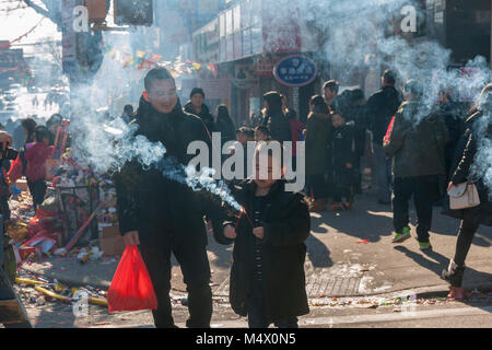 Brooklyn, USA. 18th Feb, 2018. Visitors light sparklers in the neighborhood of Sunset Park in New York, Brooklyn's Chinatown, celebrating the Year of the Dog at the annual Chinese Lunar New Year Parade on Sunday, February 18, 2018. Sunset Park is home to many Chinese immigrants and is known as Brooklyn's Chinatown. Credit: Richard Levine/Alamy Live News Stock Photo