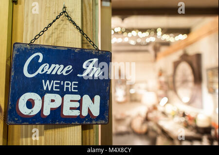 A sign reads, Come in We're Open. Stock Photo