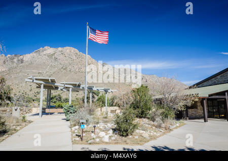 Flag waving in the air in front of Guadalupe Mountains at Visitor Center, the first stop in Guadalupe Mountains National Park for information on hikin Stock Photo