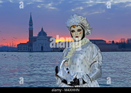 A harlequin in front of the San Giorgio Maggiore Church during the Carnival of Venice (Carnevale di Venezia) in Venice, Italy Stock Photo