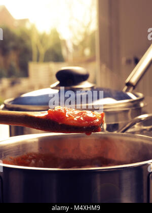 Cooking tasty tomato sauce with garlic onions and spicy herbs, Stock Photo