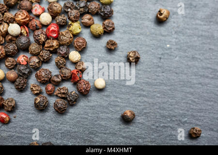 mixture of pepper peas powder scattered on a slate plate. Closeup Stock Photo