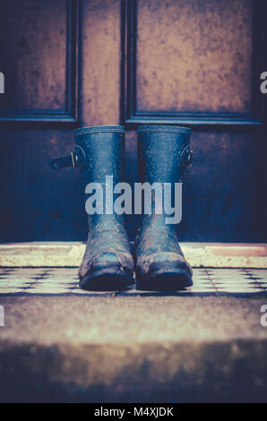 Close Up Of Dirty Rubber Boots Outside a Front Door in Scotland, UK Stock Photo