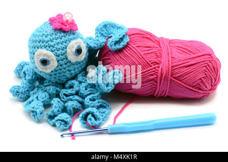 crocheted octopus of wool with woolball and crochet hook on white isolated  background Stock Photo