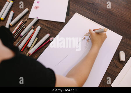 Female entrepreneur sketching a design at her table. Cropped shot of fashion designer making a drawing at her desk. Stock Photo