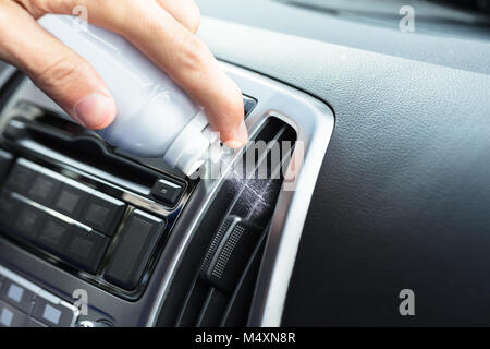 Person's Hand Cleaning Air Conditioner With Bottle In Car Stock Photo