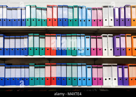 colorful ring binder folder on white shelves, office stationary Stock Photo