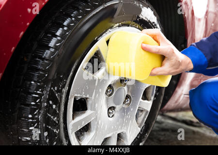 Worker Hands Washing Car Wheel With Yellow Sponge Stock Photo