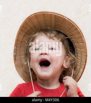 Blond curly-haired child straw hat Stock Photo