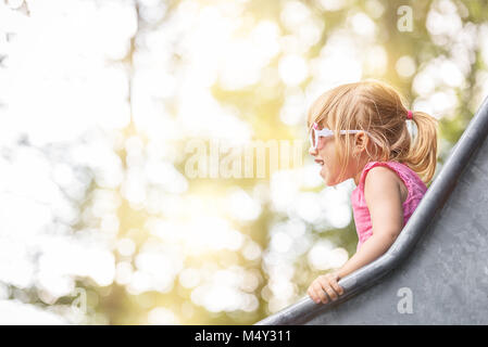 Happy blond girl on a slide Stock Photo