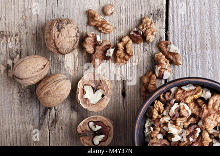 walnuts in a clay plate on a wooden background. top view Stock Photo