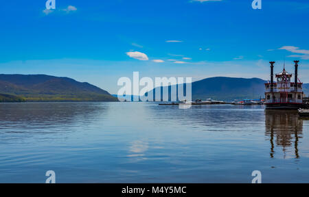 Red and white river boat and mountains reflected on the Hudson River in Upstate New York. Stock Photo