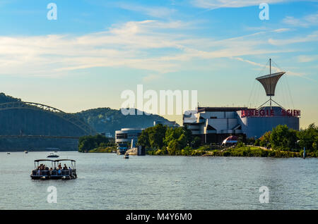 View of Ohio River with bridge and the Carnegie Science Center museum at center, with a party boat in the foreground, as seen from Point State Park. Stock Photo